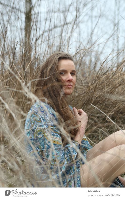 side portrait of young woman in summer dress sitting barefoot between bushes in nature pretty Life Contentment Trip Young woman Youth (Young adults)