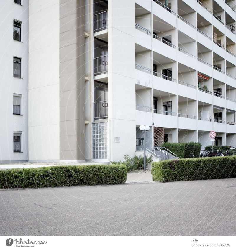 living space Plant Bushes House (Residential Structure) High-rise Manmade structures Building Architecture Facade Balcony Window Door Gloomy Town Colour photo