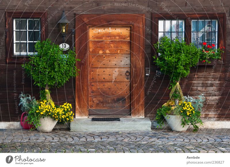 farm Village House (Residential Structure) Hut Wall (barrier) Wall (building) Facade Door Doormat Brown Wood Wooden house Bushes Entrance Rustic Groomed Idyll