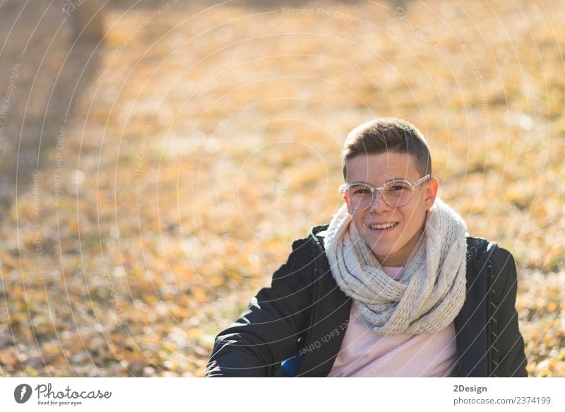 Stylish smiling teenager sitting on the ground in a city park Lifestyle Joy Happy Schoolchild Academic studies PDA Human being Masculine Boy (child) Young man