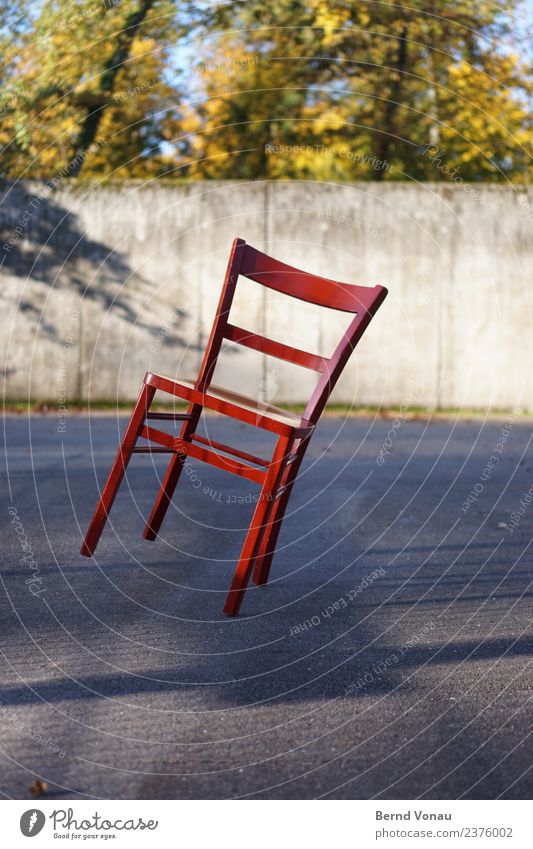 Red wooden chair in inclined position on sunny asphalt Wood Bright Chair Multicoloured Tilt Balance Insecure four-legged four-legged friends Classic Concrete