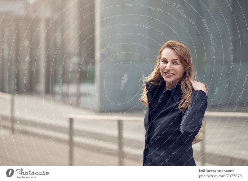 Happy smiling woman standing in the wind Business Woman Adults 1 Human being 45 - 60 years Wind Building Street Blonde Smiling Laughter Stand Happiness