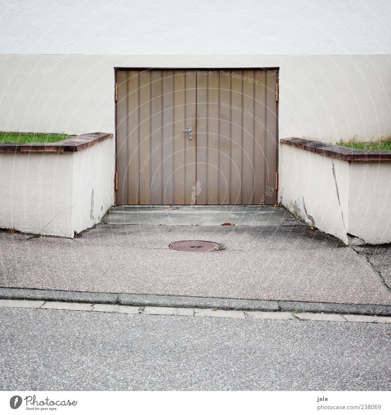 garage Grass Meadow Wall (barrier) Wall (building) Facade Garage Garage door Highway ramp (entrance) Street Sidewalk Gloomy Brown Gray Green Asphalt