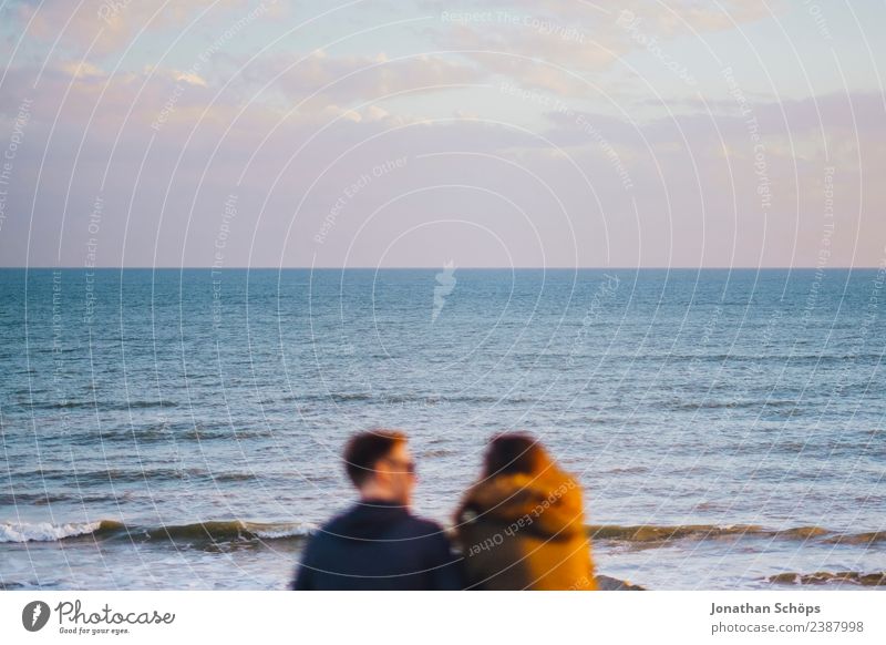 Couple sits by the sea Partner 2 Human being Sky Sunrise Sunset Waves Coast Brighton Great Britain Europe Touch Smiling To talk Esthetic Together Happy