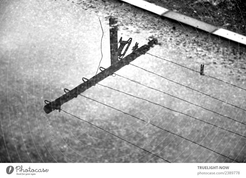 Laundry line and pole reflected in puddle on the way Garden Earth Water Clouds Weather Bad weather Rain Stone Sand Metal Wait Simple Wet Retro Gray Black White