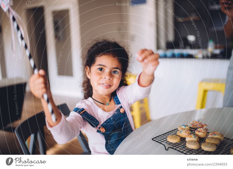 happy african girl sitting at kitchen table with baked cookies Dessert Lifestyle Joy Happy Beautiful Kitchen Child Human being Woman Adults Infancy Smiling