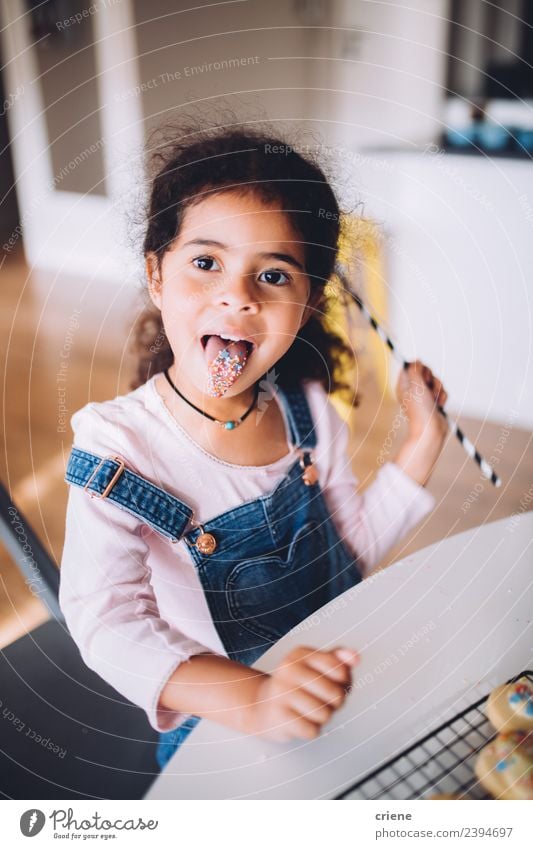 african young girl stretching out tongue while eating sweets Dessert Lifestyle Joy Happy Beautiful Table Kitchen Child Human being Woman Adults Infancy Smiling