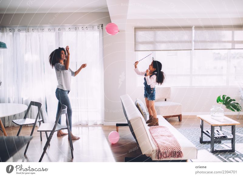 african mother and daughter playing with balloon in living room Happy Decoration Child Woman Adults Mother Family & Relations Infancy Smiling Happiness Cute