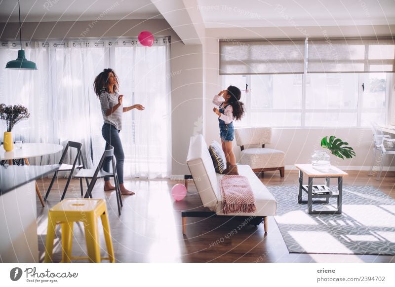 african mother and daughter playing with balloon in living room Happy Playing Decoration Living room Child Woman Adults Mother Family & Relations Infancy