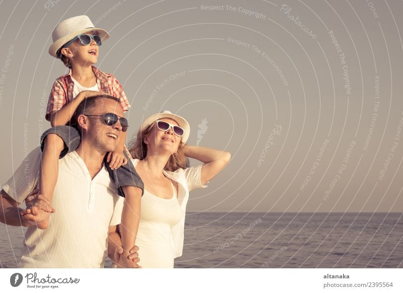 Happy family standing on the beach at the day time. People having fun outdoors. Concept of summer vacation and friendly family. Lifestyle Joy Relaxation