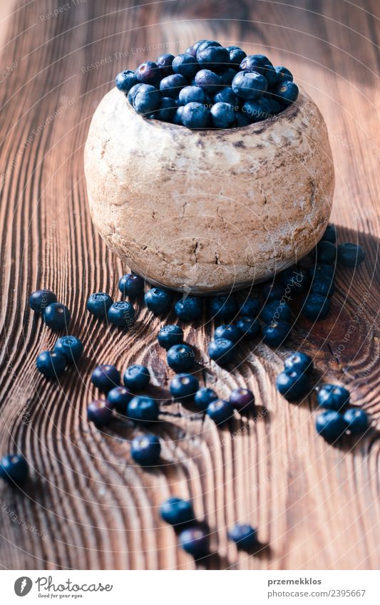 Freshly gathered blueberries put into old ceramic bowl Food Fruit Nutrition Organic produce Vegetarian diet Diet Bowl Summer Table Nature Wood Authentic