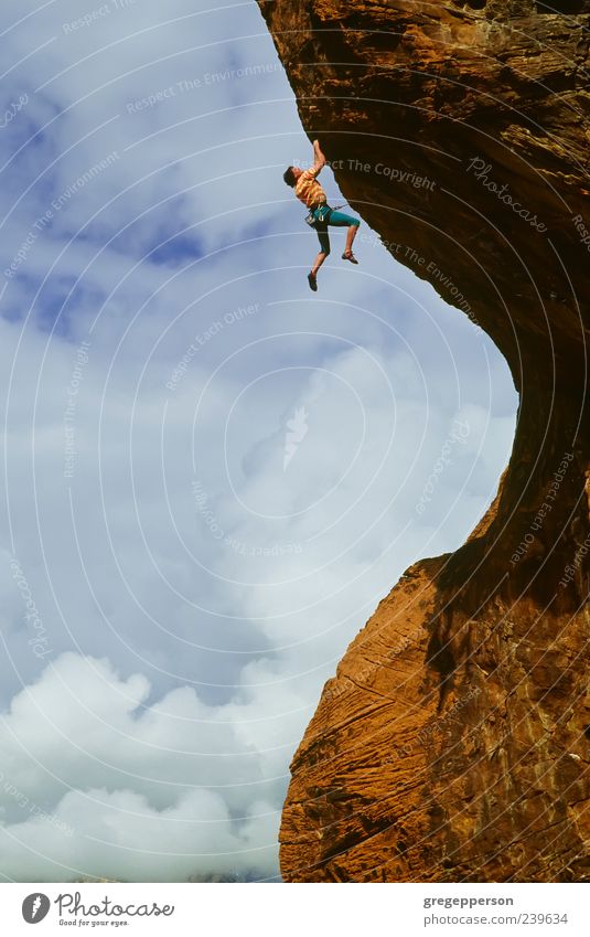 Rock climber clinging to a cliff. Adventure Sports Climbing Mountaineering Success Young man Youth (Young adults) 1 Human being 18 - 30 years Adults Storm