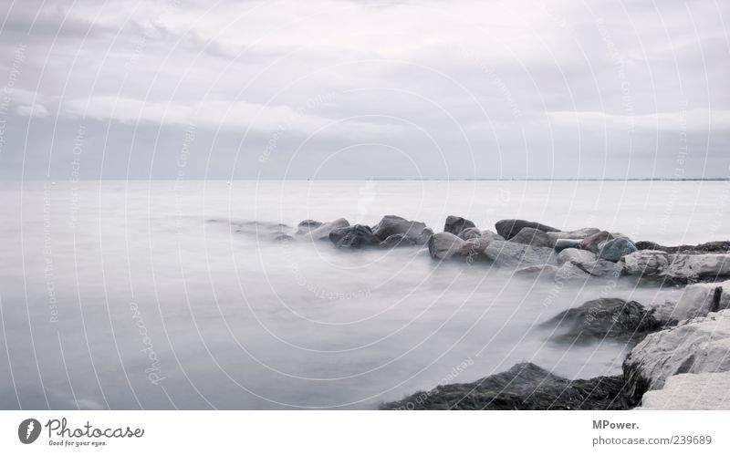 Fehmarn Baltic Sea Ocean Water Stone Sand Horizon Gray Gloomy Colorless Deserted Fog Bad weather Long exposure Waves Clouds Coast Lakeside Beach Rain Rock