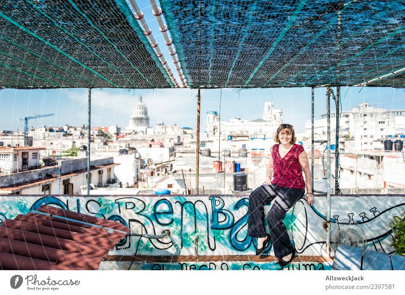 young woman sitting on a roof in Havana Cuba United States Capitol Skyline Vantage point Apartment Building Tumbledown Construction site Blue sky Cloudless sky