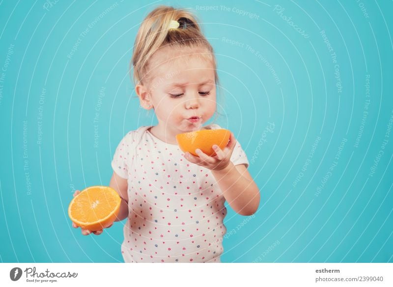 baby eating an orange on blue background Food Fruit Orange Nutrition Eating Breakfast Lunch Human being Feminine Baby Girl Infancy 1 3 - 8 years Child Diet