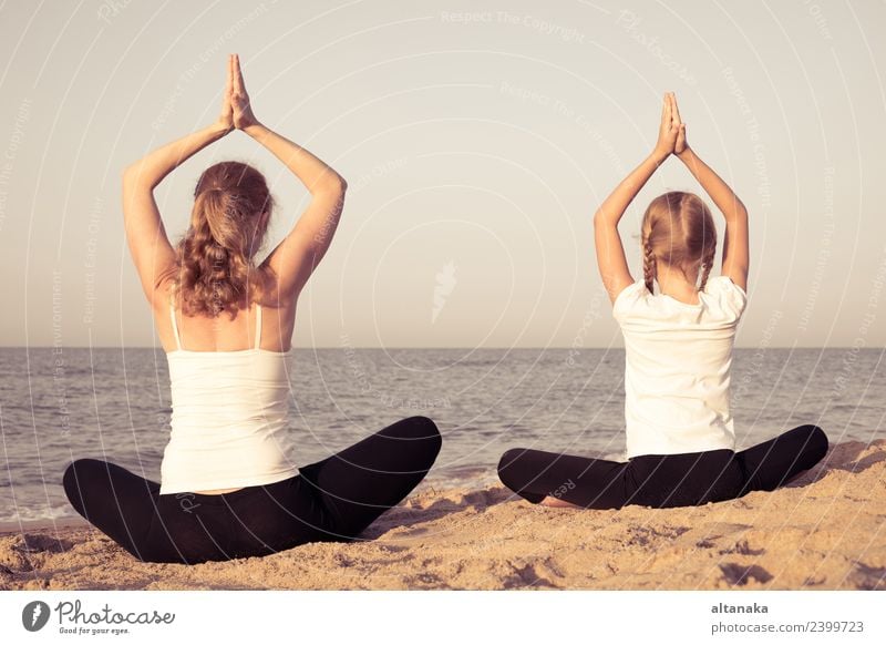 Mother and daughter doing yoga exercises on the beach. Lifestyle Joy Happy Body Wellness Harmonious Relaxation Meditation Leisure and hobbies Camping Summer