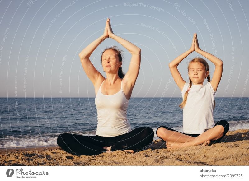 Mother and daughter doing yoga exercises on the beach. Lifestyle Joy Happy Body Wellness Harmonious Relaxation Meditation Leisure and hobbies Camping Summer