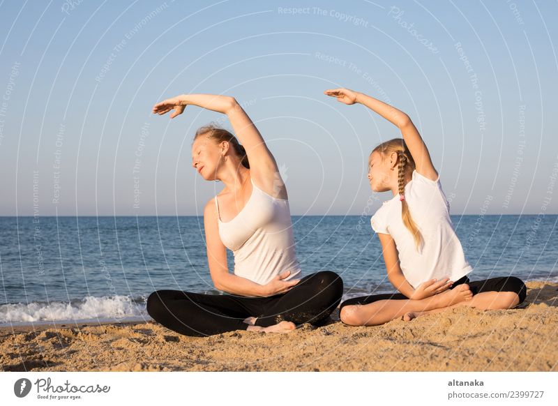 Mother and daughter doing yoga exercises on the beach. Lifestyle Joy Happy Body Wellness Harmonious Relaxation Meditation Leisure and hobbies Camping Summer