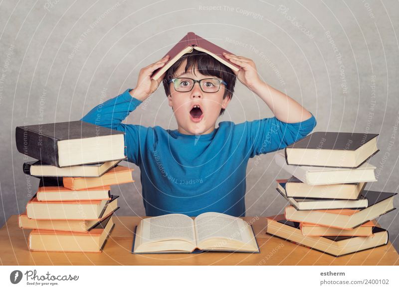 surprised boy with books on a table Lifestyle Joy Reading Human being Masculine Child Toddler Infancy 1 8 - 13 years Culture Movement Think To hold on Fitness