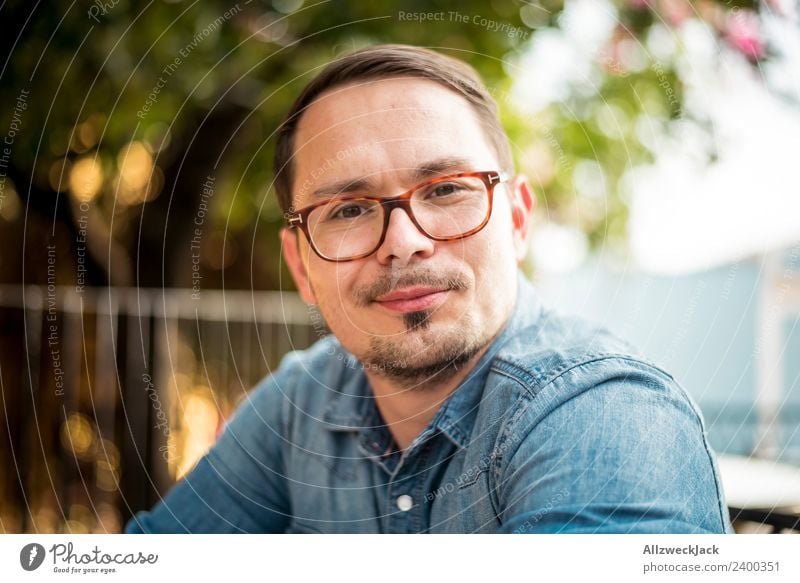 Portrait of a young man with glasses Day Exterior shot Portrait photograph 1 Person Young man Person wearing glasses Eyeglasses Facial hair Moustache