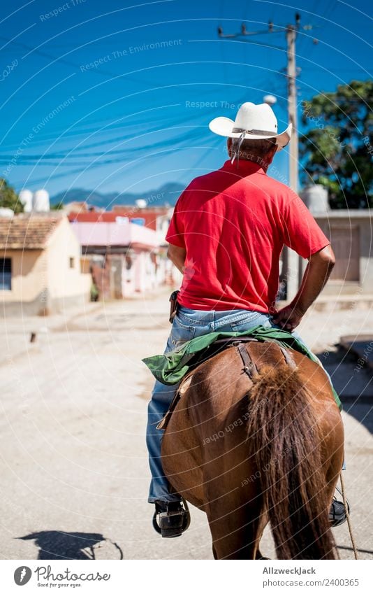 Man on a horse rides through Trinidad in Cuba Trinidade Socialism Old Historic Retro Old-school Old fashioned Exterior shot Day Summer Sun Blue sky Warmth