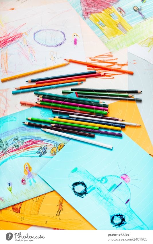 Crayons scattered on desktop filled with colorful drawings Lifestyle Joy Happy Beautiful Handcrafts Table Education Kindergarten Child School Art Stationery