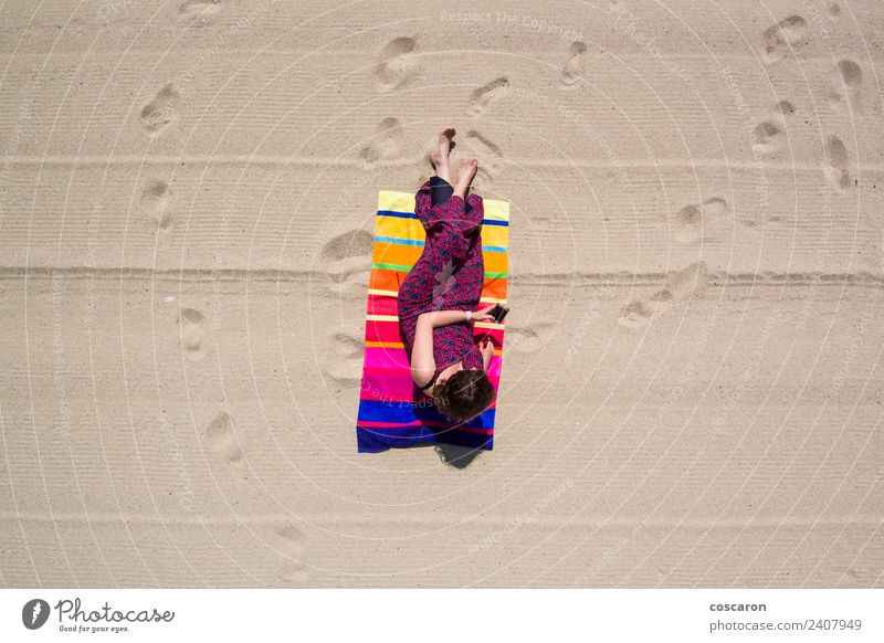 Woman in a towel on the beach looking at a mobile Lifestyle Elegant Joy Happy Beautiful Summer Sun Sunbathing Beach Ocean Telephone PDA Adults Nature Aircraft