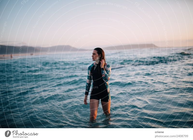 caucasian woman walks out of water in wetsuit Beautiful Summer Sun Beach Ocean Sports Human being Woman Adults Nature Rock Brunette Think Dream Bright Long Wet