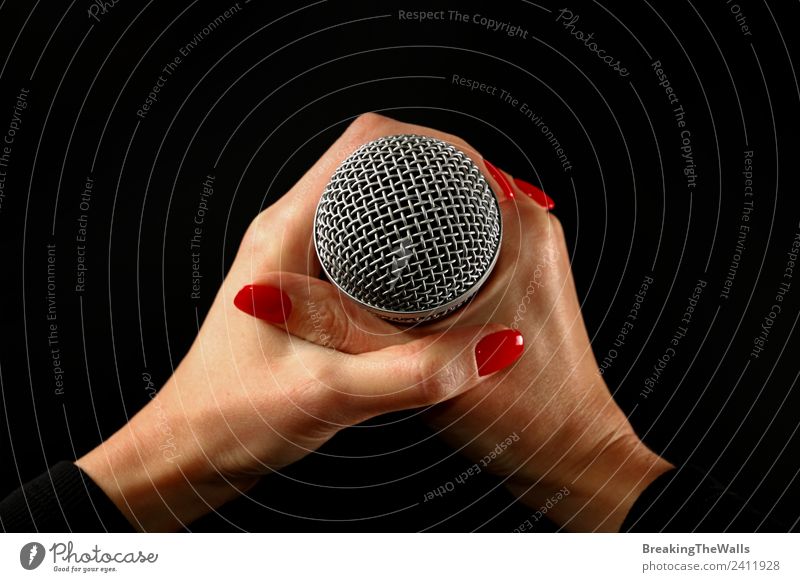 Woman holding microphone with two hands over black Human being Adults Hand 1 Shows Music Concert Stage Singer Musician Record Media Television Red Black