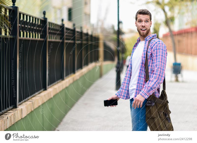 Young bearded man surprised in urban background Lifestyle Style Happy Vacation & Travel Telephone PDA Human being Young man Youth (Young adults) Man Adults 1