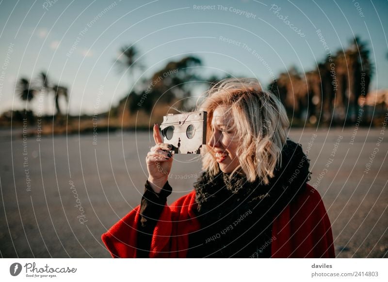 Blonde white woman holding an old VHS tape and playing with it. Lifestyle Joy Leisure and hobbies Human being Young woman Youth (Young adults) Woman Adults 1