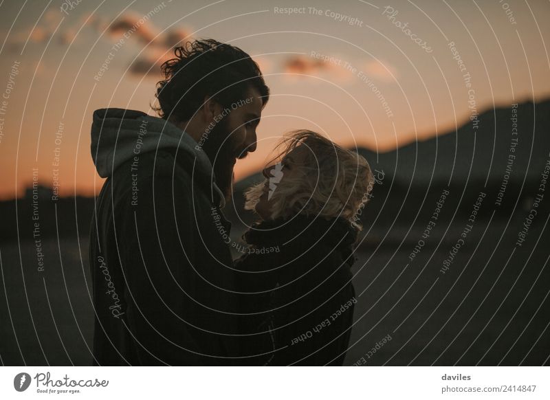 Bearded man and blonde woman looking to each other while they hug, at dusk. Lifestyle Joy Human being Young woman Youth (Young adults) Young man Couple 2