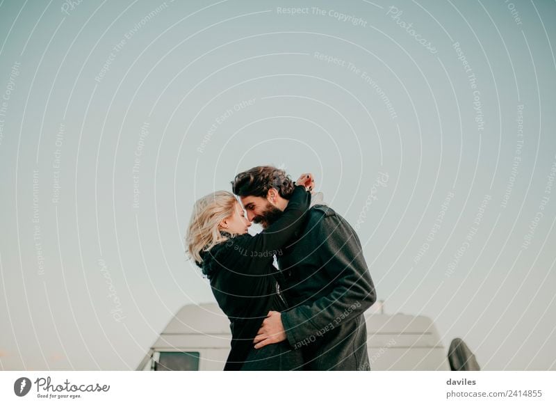 Blonde girl and bearded man embracing outdoors with a van in the background. Lifestyle Joy Vacation & Travel Trip Camping Mountain Human being Young woman