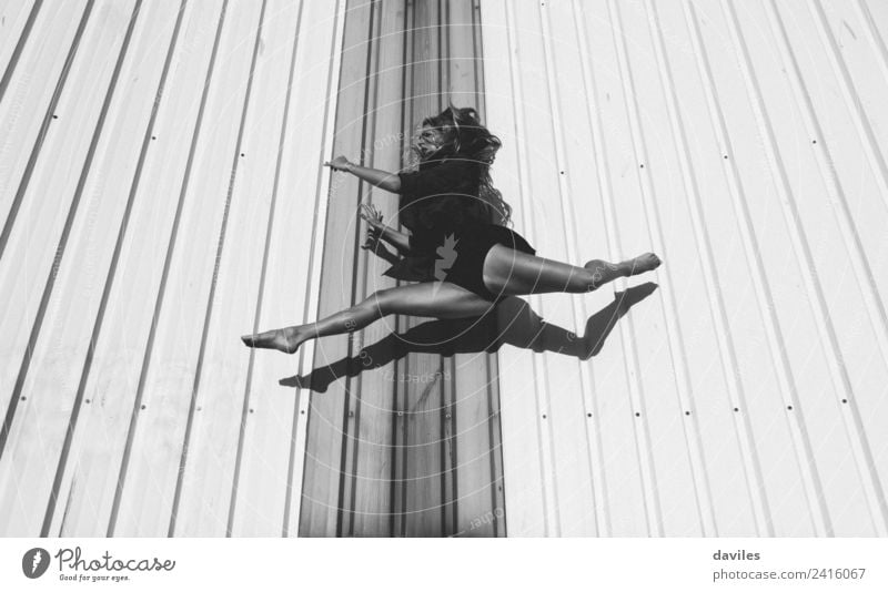 Black and white portrait of dancer jumping and suspended, with an industrial wall in the background Lifestyle Leisure and hobbies Sports Fitness Sports Training