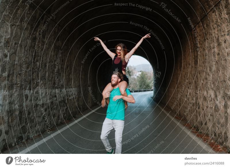 Happy young couple having fun together Lifestyle Joy Vacation & Travel Human being Woman Adults Man Couple 2 Street Stone Smiling Love Carrying Happiness Cute