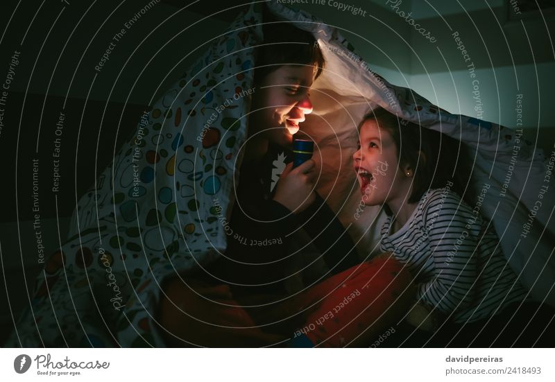 Boy with sister lighting up with flashlight Lifestyle Joy Happy Beautiful Calm Bedroom Child Human being Boy (child) Woman Adults Man Sister Family & Relations