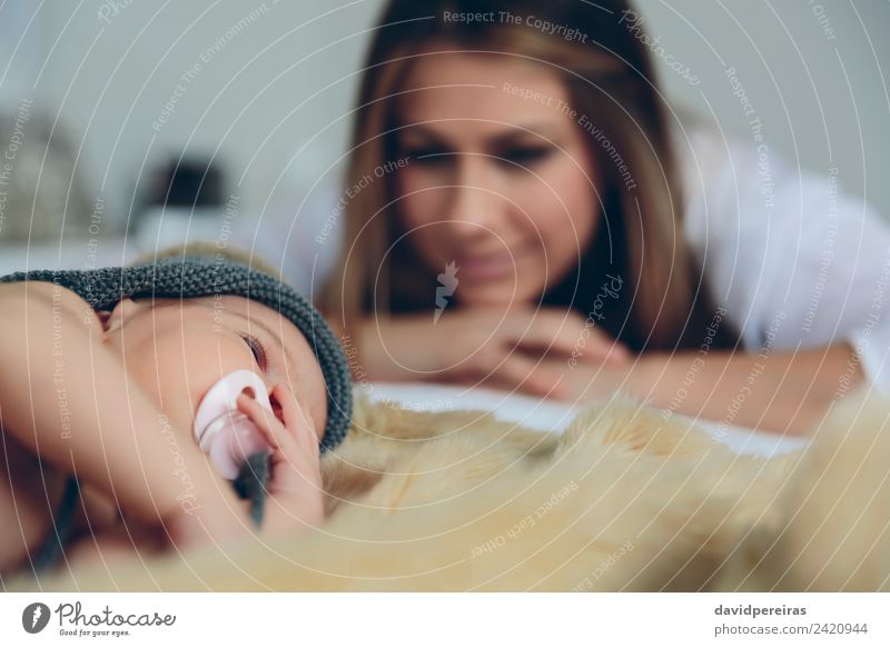 Baby sleeping on a blanket while her mother looks Happy Beautiful Relaxation Calm Bedroom Child Human being Woman Adults Mother Family & Relations Hat Smiling