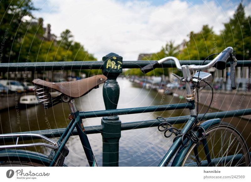 kind Bicycle Old town Bridge Passenger traffic Boating trip Motorboat Stand Wait Blue Green Black Silver Amsterdam hollandrad Bridge railing Bicycle saddle