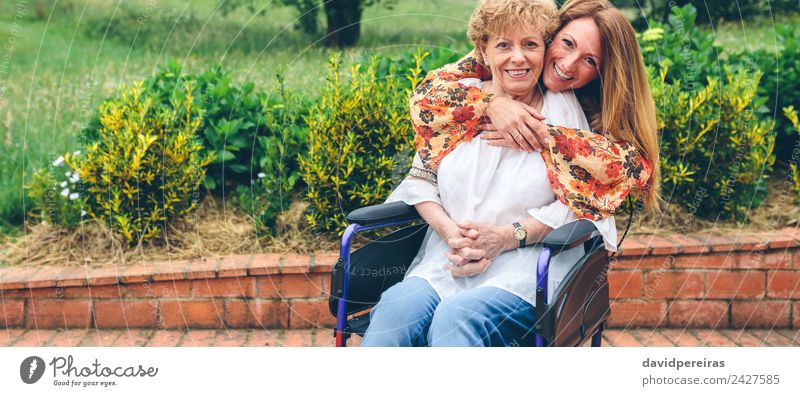 Daughter embracing senior mother in wheelchair Lifestyle Happy Health care Relaxation Garden Human being Woman Adults Mother Grandmother Family & Relations