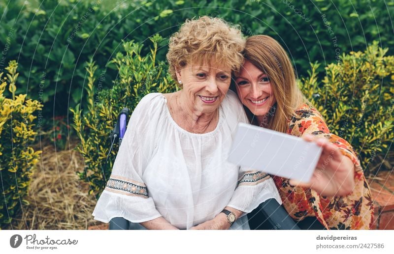 Woman taking selfie with older mother in wheelchair Lifestyle Happy Health care Relaxation Garden PDA Human being Adults Mother Grandmother Family & Relations