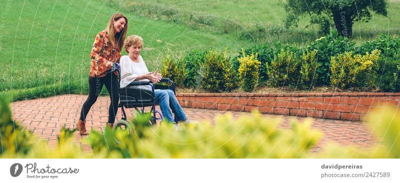 Woman carrying her mother in a wheelchair Lifestyle Happy Health care Relaxation Garden To talk Human being Adults Mother Grandmother Family & Relations Nature