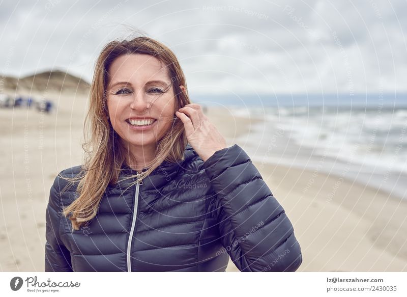 Attractive woman on a windswept beach Face Leisure and hobbies Freedom Beach Ocean Woman Adults 1 Human being 45 - 60 years Sand Clouds Autumn Storm Wind Coast