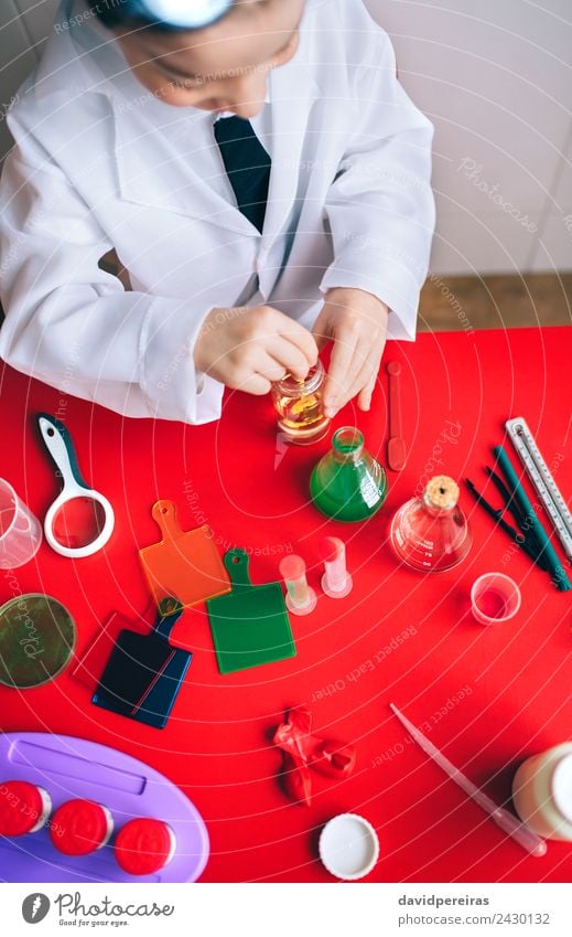 Little boy scientist mixing liquid in bottle Bottle Spoon Playing Flat (apartment) Table Science & Research Child Classroom Laboratory Human being Boy (child)