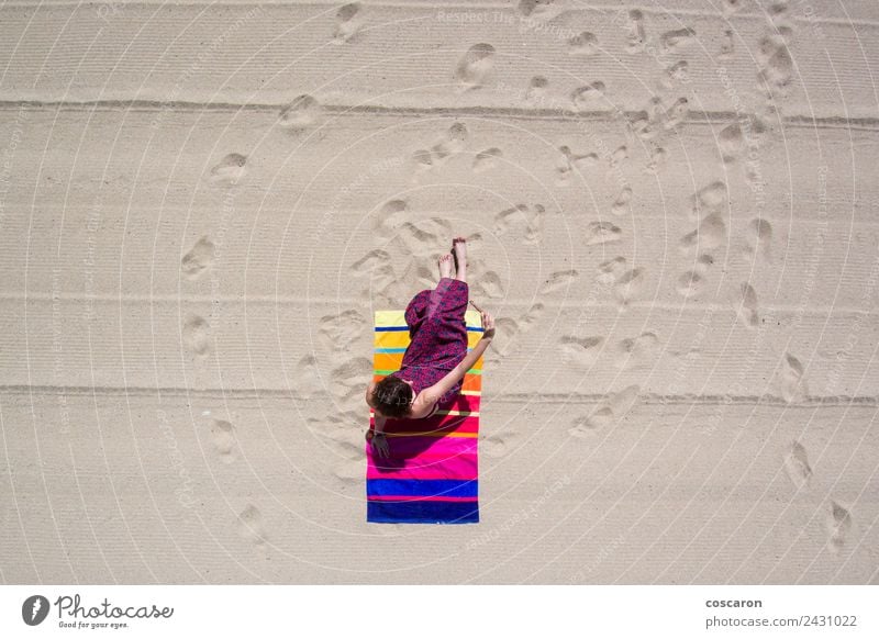 Woman in a towel on the beach looking at a mobile. Aerial shot. Made with drone. Lifestyle Elegant Joy Happy Beautiful Summer Sun Sunbathing Beach Ocean