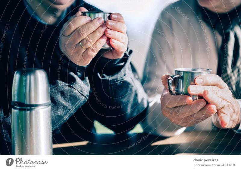 Senior couple hands holding cups with hot coffee Coffee Tea Lifestyle Relaxation Leisure and hobbies Table Human being Woman Adults Man Couple Hand Warmth Wood