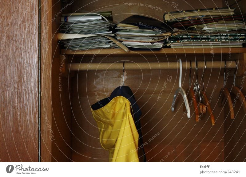 behind grandma's curtains V Jacket Far-off places Rain jacket Magazine Hanger Wood Rod Cupboard Yellow Brown Paper Past Memory Colour photo Interior shot