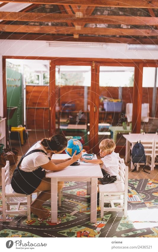 Teacher helping little boy in preschool with homework Happy Beautiful Vacation & Travel Chair Table Child School Study Human being Boy (child) Woman Adults Man