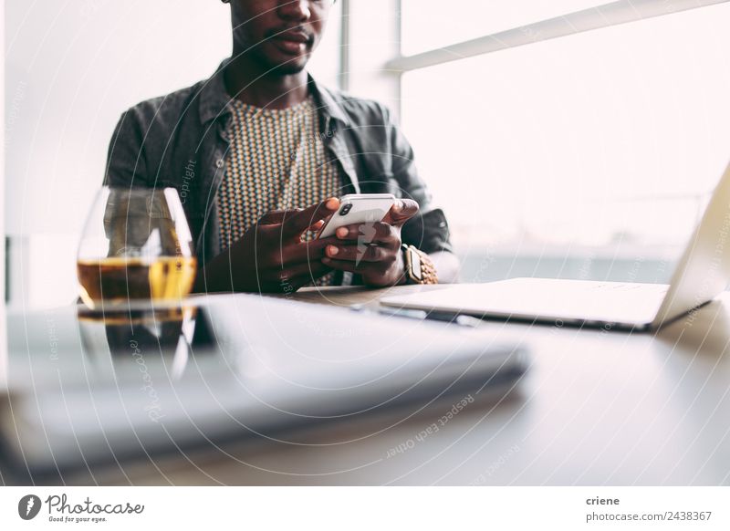 young afrcian man being busy with smartphone and laptop at home Drinking Design Happy Table Work and employment Business Telephone PDA Computer Notebook