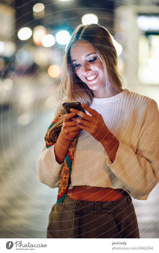 Blonde woman looking at her smartphone in the street. Lifestyle Style Happy Beautiful Hair and hairstyles Telephone PDA Human being Feminine Young woman