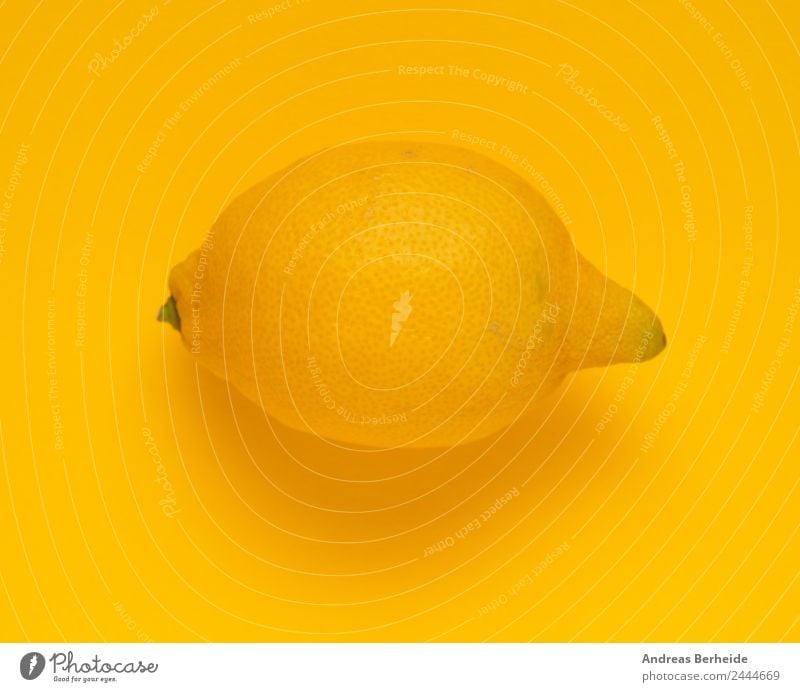 An organic lemon on a yellow background Fruit Nutrition Organic produce Vegetarian diet Diet Healthy Eating Funny Sour Yellow Organic farming Lemon Tone-on-tone